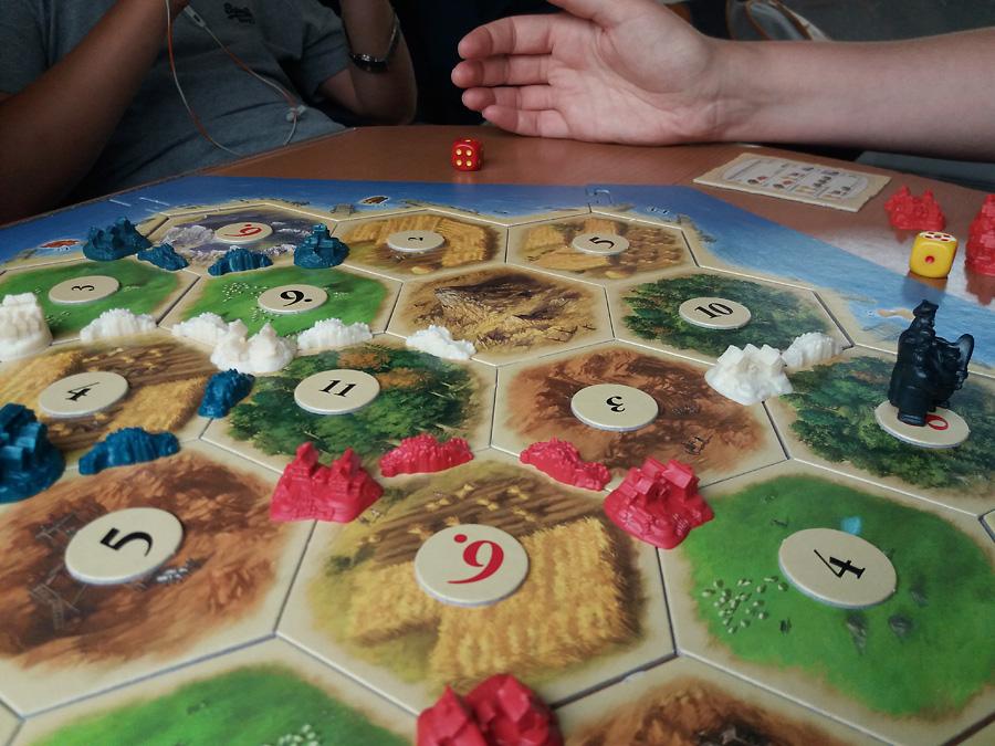 Catan: nopan heittoa junan pöydällä